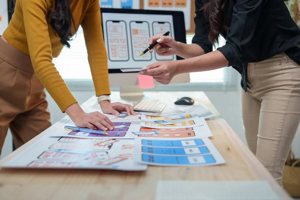 Fotografía de dos mujeres analizando la publicidad impresa que realizaron